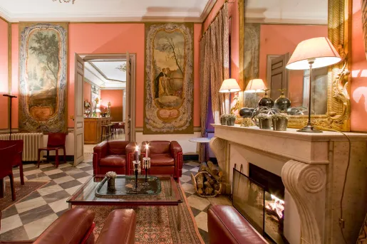Indoor foyer with red, cushioned chairs next to a fireplace