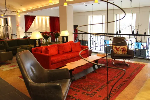 red couch and leather chairs in hotel living room