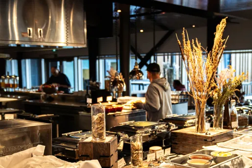 Indoor dining hall with food warmers, as people are serving plates of food