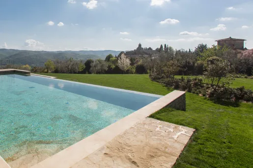 Outdoor infinity pool on a grassy hill, looking out to an open valley