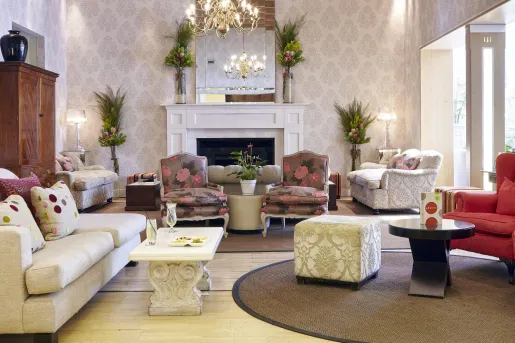 White lobby room, with flower patterned pillows and cushioned chairs