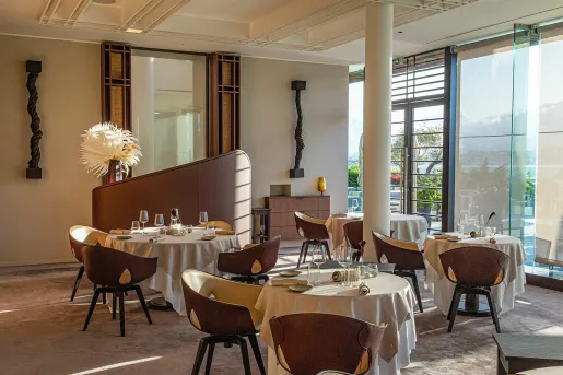 Dining area with brown and white chairs surrounding circular dining tables
