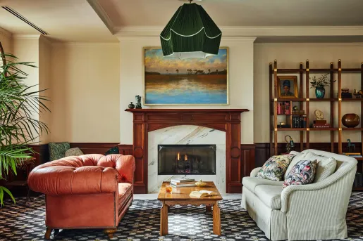 Stone and wood fireplace, with two red and white cushioned sofas in front