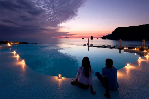 candlelit hotel pool overlooking sunset