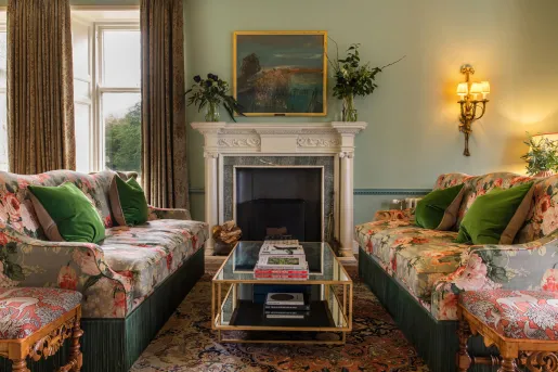 couches with flower print next to fireplace