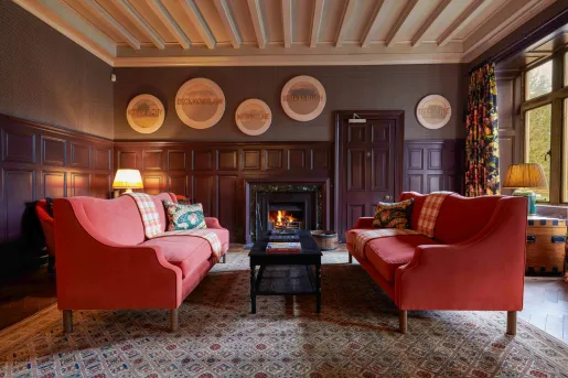 red couches in wood paneled room