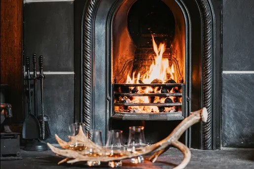 Black stone fireplace with wine glasses on a table in front