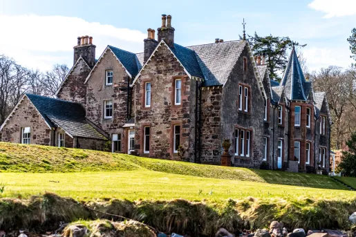 Rustic, brown brick building with an open grass area in front
