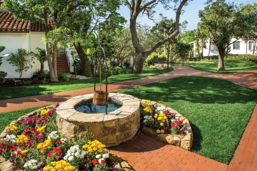 Outdoor garden with a water well and brick walkways