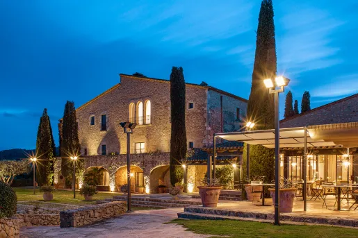 Exterior of hotel Mas Torrent lit up at night