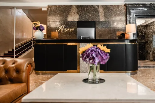 Hotel lobby with front desk and arm chairs
