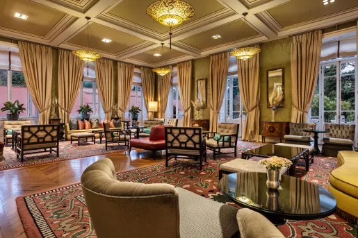 Lobby with large, tan curtains and cushioned chairs throughout the room