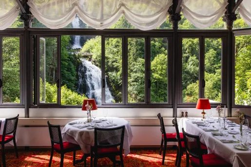 Indoor dining area with large windows looking out to a waterfall