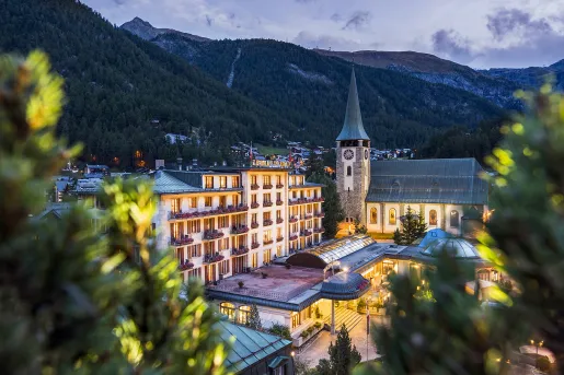 Hotel with clocktower in front of mountains