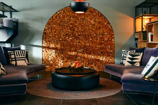 Indoor waiting area with blue sofas and a wooden art piece on the wall