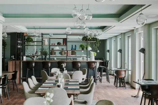 Dining area and bar with light green walls and gray chairs