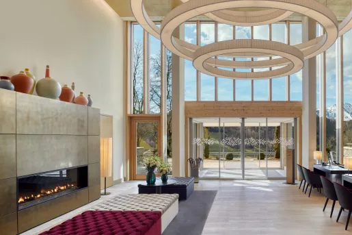 Indoor lobby with a stone fireplace and cushioned sofas in the center