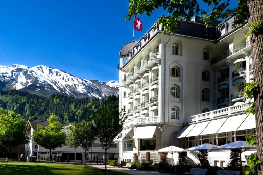 large hotel next to a snow capped mountain
