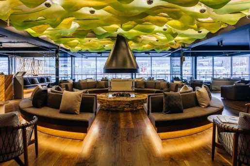 hotel lobby with circular couches and fire pit and green roof