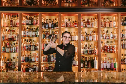 bar tender making cocktails behind bar