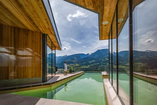 Woman standing in a robe at an oudoor pool
