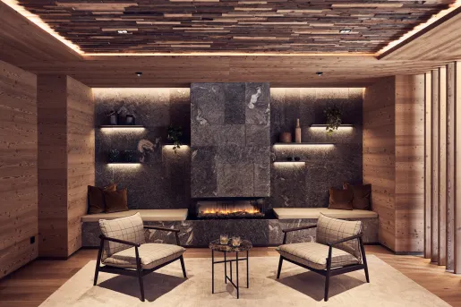 Indoor seating area with two cushioned chairs and a stone fireplace in the background