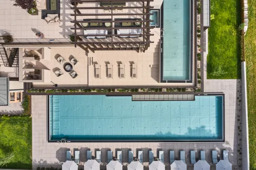Sky view of outdoor pool, surrounded by chairs and umbrellas