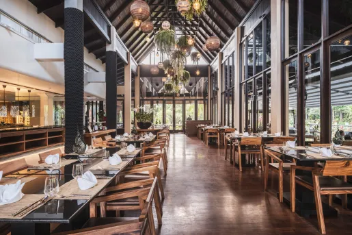 Indoor dining hall with wooden chairs and large windows on the walls