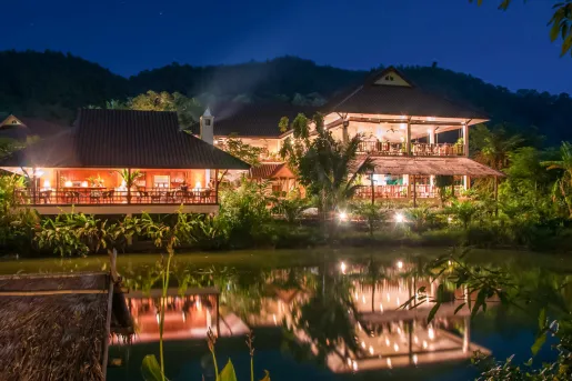 Outdoor bungalows illuminated by lights in the evening