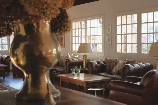 Indoor lounge with copper vases and brown cushioned sofas