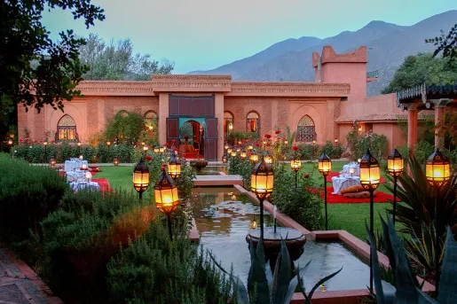 Outdoor garden in front of a stone building and a small pond