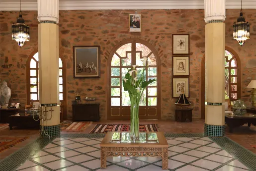 Indoor lobby with a vase full of plants in the center and two large pillars on either side