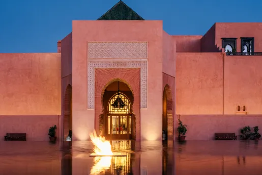 Large stone building with an infinity fountain and a firepit in front