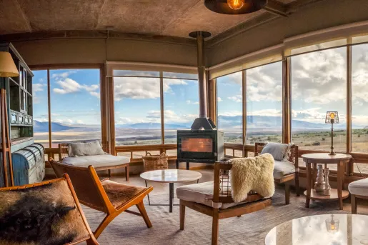 Cabin room with wooden chairs with cushions in front of a wood furnace