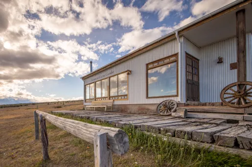 Metal building with a wooden porch and wooden wheels in front
