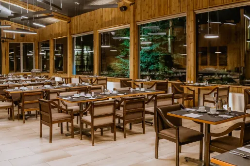 Indoor cabin dining hall with brown cushioned chairs and brown tables