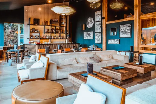 Lounge with cushioned couches and a bar in the background