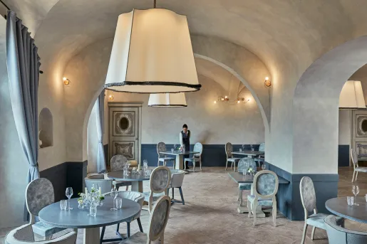 Dining area with large stone walls, and blue and gray tables and chairs