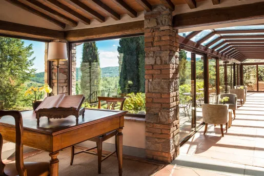 Hallway and lounge area with walls made of windows, looking out to an outdoor garden