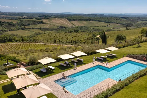 pool surrounded by lounge chairs and farmland 