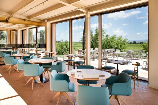 Dining hall with blue cushioned chairs and large windows