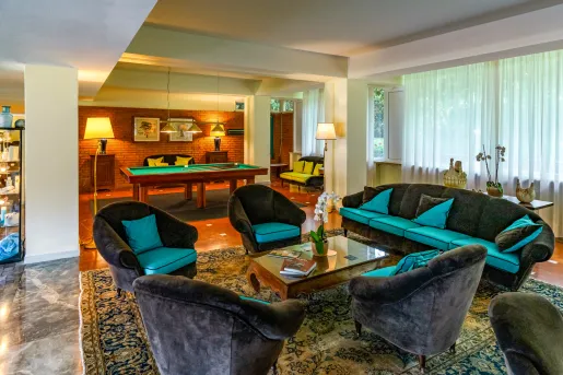 Lounge with gray and blue sofas and a billiards table in the background