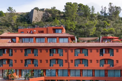 Red hotel building with individual balconies per room