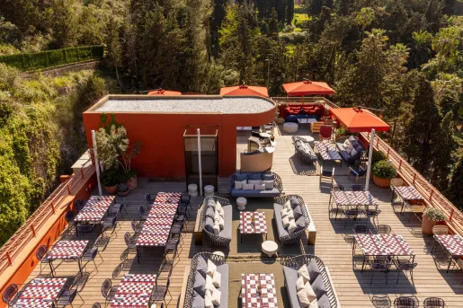 Outdoor dining area with a red building and gray cushioned seating
