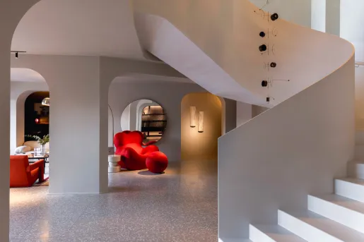Lobby with red, cushioned chairs and a white staircase