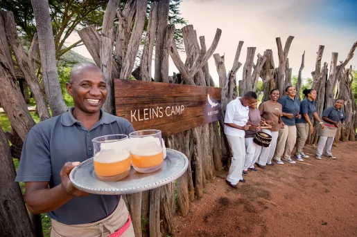 Hotel staff greeting guests at entrance sign
