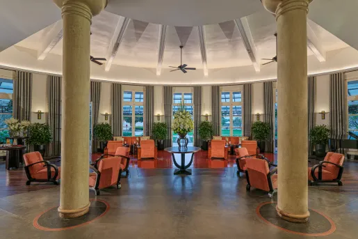 Hotel lobby with stone flooring and two large, stone pillars