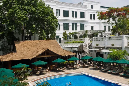 outdoor swimming pool surrounded by green umbrellas