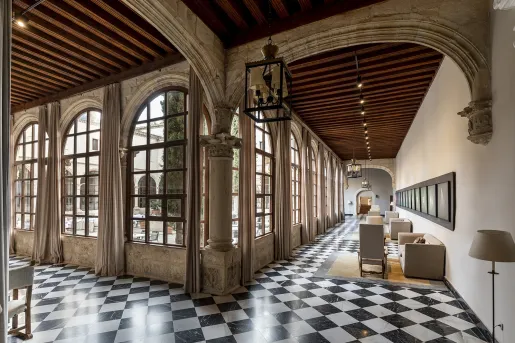 Rustic building interior with stone pillars and checkerboard flooring