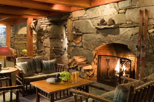 Stone fire place with wood furniture and chairs in front